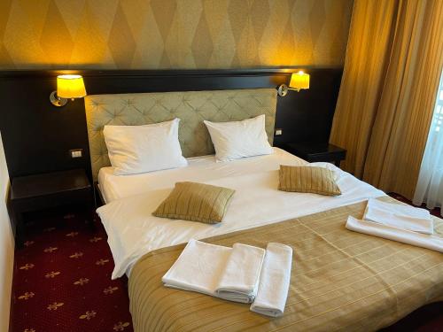 a hotel room with a bed with two towels on it at Melin Residence in Orşova