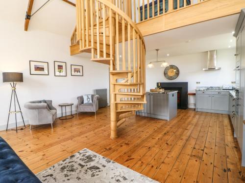 a living room with a spiral staircase and a kitchen at Greystead Institute in Hexham