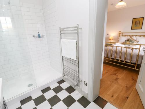 a bathroom with a shower and a checkered floor at Greystead Institute in Hexham