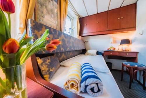 Una cama en una habitación con un jarrón de flores en River hotel KÖNIGSTEIN, en Praga