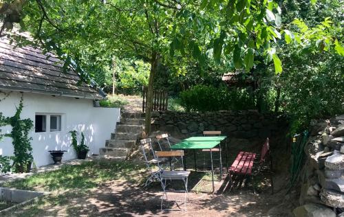 a patio with a table and chairs under a tree at Kofal Pince in Raposka