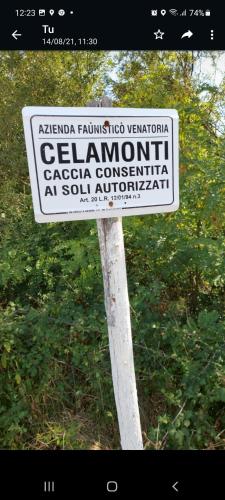 a white sign on a pole in the grass at Molino della Tuoma in San Quirico dʼOrcia