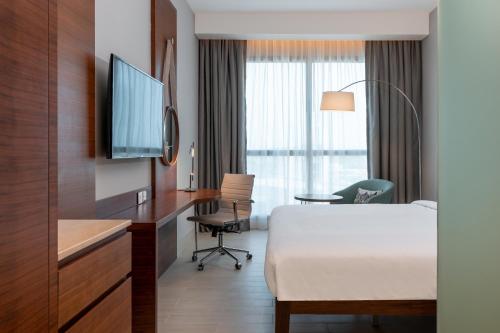 a hotel room with a bed and a desk and a tv at Radisson Blu Hotel, Juba in Juba
