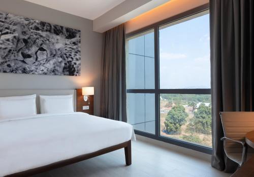 a hotel room with a bed and a large window at Radisson Blu Hotel, Juba in Juba