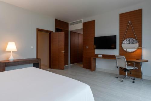 a hotel room with a bed and a desk and a television at Radisson Blu Hotel, Juba in Juba