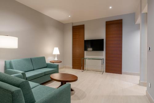 a living room with two blue chairs and a tv at Radisson Blu Hotel, Juba in Juba