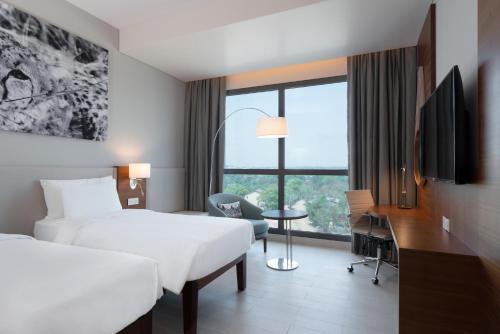 a hotel room with two beds and a desk and a window at Radisson Blu Hotel, Juba in Juba