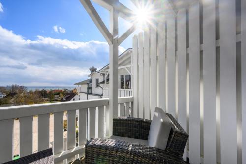 a balcony with a white fence and a chair at Koopmanns Hotel und Lädchen in Göhren
