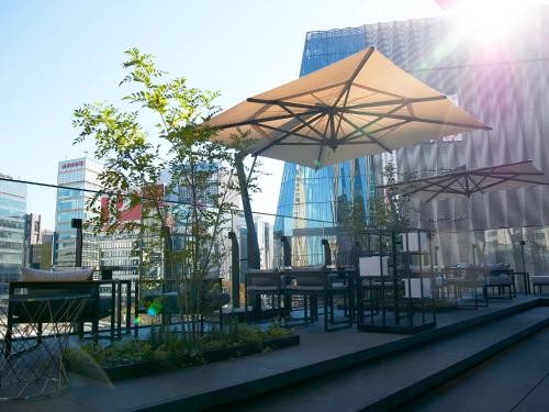 a patio with tables and chairs and umbrellas at The Gate Hotel Tokyo by Hulic in Tokyo