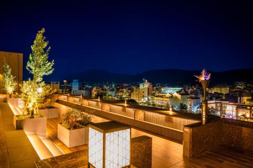 a balcony with a view of a city at night at Sora Niwa Terrace Kyoto Bettei in Kyoto