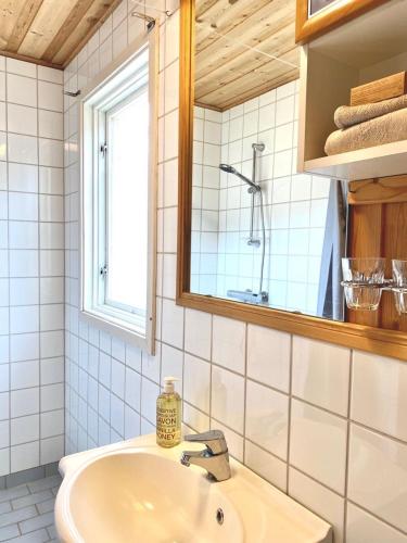 y baño con lavabo y espejo. en Stort og autentisk hus i Skjåk - kort vei til Lom!, en Skjåk