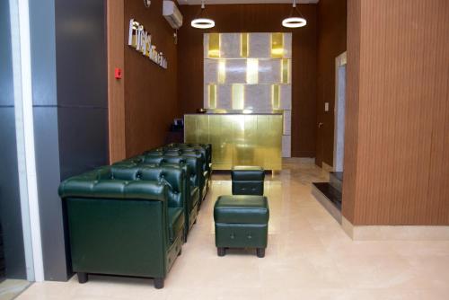 a row of green chairs in a waiting room at TGS Dine Inn in Port Blair