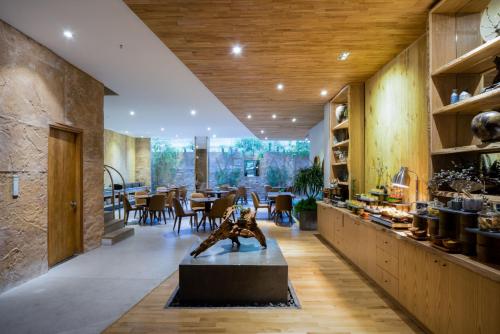 a dining room with a table and a statue in the middle at Silverland Yen Hotel in Ho Chi Minh City