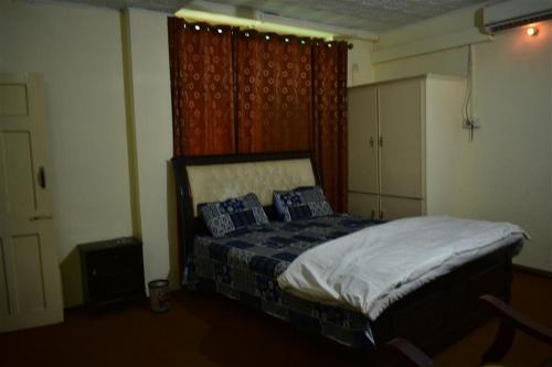 a bedroom with a bed with blue sheets and blue pillows at AJK Guest House in Muzaffarabad