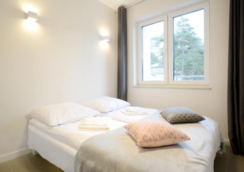 a bedroom with two beds and a window at Dwie Sosny z sauną, Sun & Snow in Ustronie Morskie