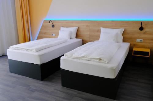 dos camas sentadas una al lado de la otra en una habitación en KIRÁLY PARK HOTEL, en Szombathely