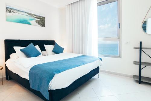 Tempat tidur dalam kamar di Almog Beach apt Hotel מלון דירות אלמוג ביץ'