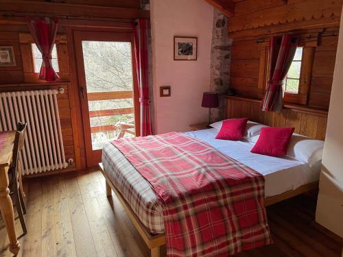 a bedroom with a bed and a large window at Maison de Noé in Arnad