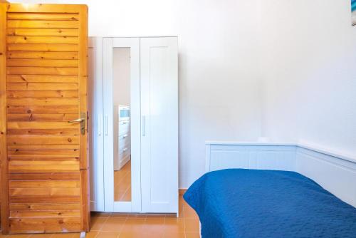 a bedroom with a blue bed and a mirror at La terrazza sul Mare in Agnone Bagni