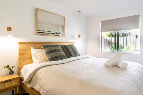 a bedroom with a large white bed with a window at Villa Marlee Margaret River in Margaret River Town