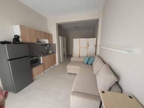 a living room with a couch and a kitchen at New apartment ,50m from the sea at Nea Irakleia. in Nea Irakleia