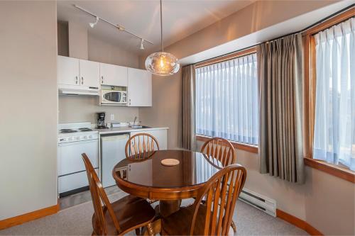a kitchen and dining room with a table and chairs at Himwitsa Lodge in Tofino
