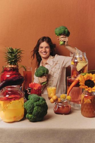a woman sitting at a table holding broccoli at Greet Hotel Colmar in Colmar