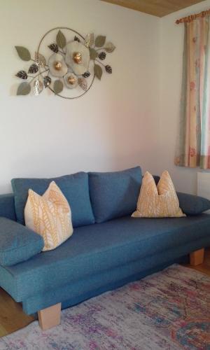 a blue couch with pillows on it in a living room at Ferienwohnungen Fahringer Diana in Kössen