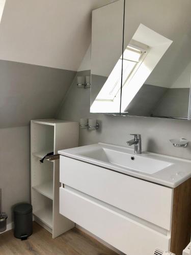a bathroom with a sink and a mirror at Pension Maren in Büsum