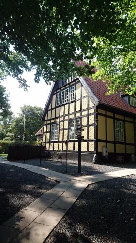a yellow and white building with a tree at Hotel Egeskoven in Viborg