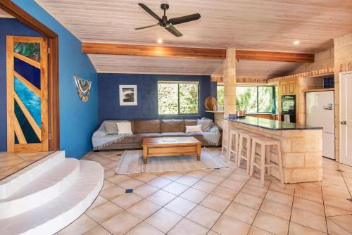 a living room with blue walls and a ceiling fan at Sea Glass Beach House Gnarabup in Gnarabup