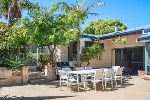 a table and chairs in front of a house at Sea Glass Beach House Gnarabup in Gnarabup