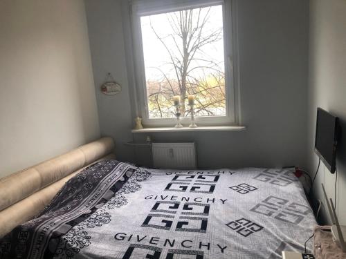 a bedroom with a bed and a window at Apartament rodzinny blisko morza in Gdańsk