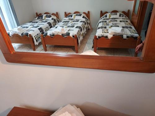 two twin beds in a room with a mirror at 85 sqm Apartments New Panorama ELECTRIC CAR ΦΩΡΤΗΣΗΣ STATION in Paralion astros