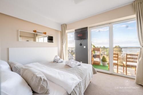 a bedroom with a bed and a large window at Laurasapartment in Jarosławiec