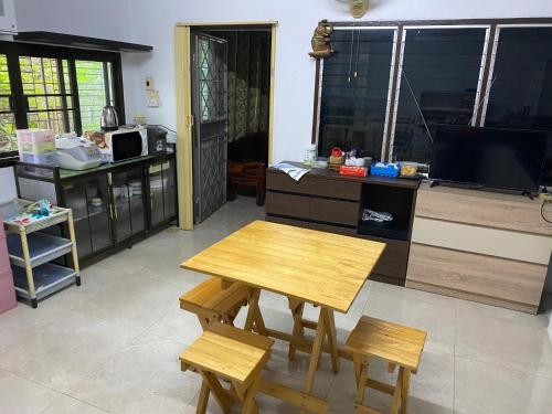 cocina con mesa y 2 sillas y TV en Pani House Hatyai 1, en Hat Yai