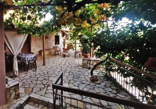 a garden with a stone patio with a fence at Panorea's Stone House in Sidhirókastron