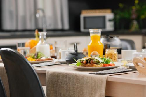 a table with two plates of food and orange juice at Belvedere Luxury Apartments & Spa in Plakias