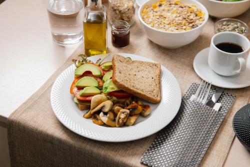 a plate of food on a table with a sandwich and toast at Belvedere Luxury Apartments & Spa in Plakias