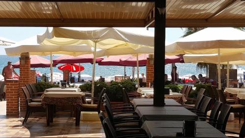 a restaurant with tables and umbrellas on the beach at Sky Alremu Apart Hotel in Side