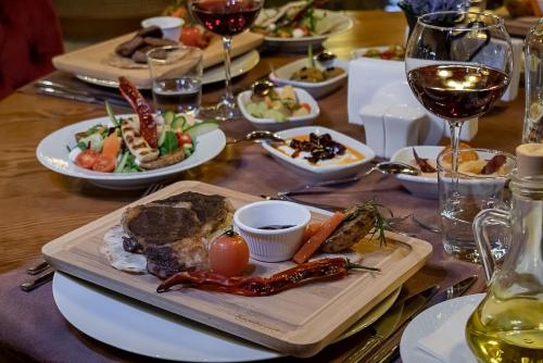 a table with plates of food and glasses of wine at ERTA SOYAK THERMAL OTEL in Çekirge