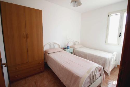 een slaapkamer met 2 bedden en een raam bij Casa Montegrappa by RENTHOUSESALENTO in San Foca