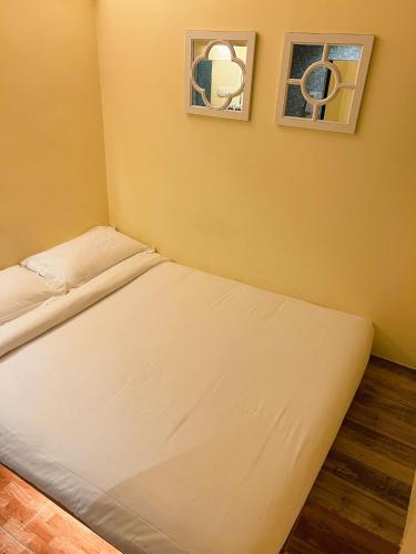 a bed in a room with two pictures on the wall at Fragrance Hotel - Classic in Singapore