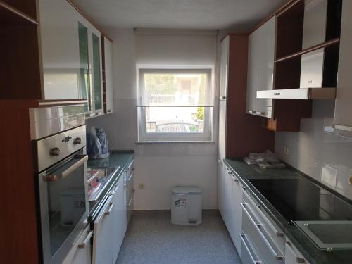 eine Küche mit weißen Arbeitsflächen und einem Fenster in der Unterkunft Villa Ana in Vodice