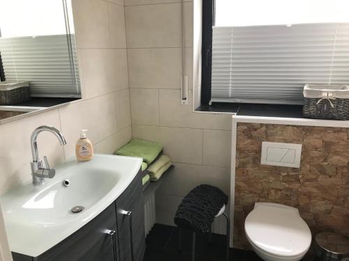 een badkamer met een wastafel en een toilet bij Ferienwohnung Wintergarten in Bad Pyrmont