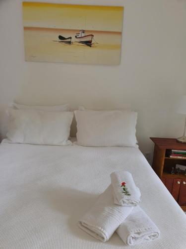 a white bed with two towels on top of it at Ohana suíte Abraão - Ilha Grande in Abraão