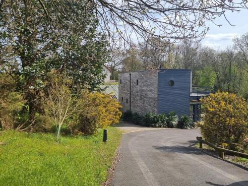 un camino de grava que conduce a una casa con un edificio en Villa avec Piscine Les Planches à Saint Valery Somme en Saint-Valery-sur-Somme
