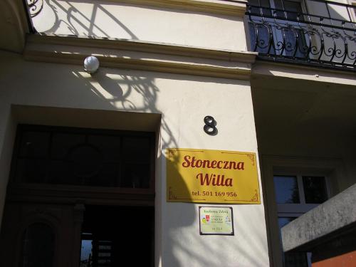 um sinal amarelo na lateral de um edifício em Słoneczna Willa & sauny em Kudowa-Zdrój