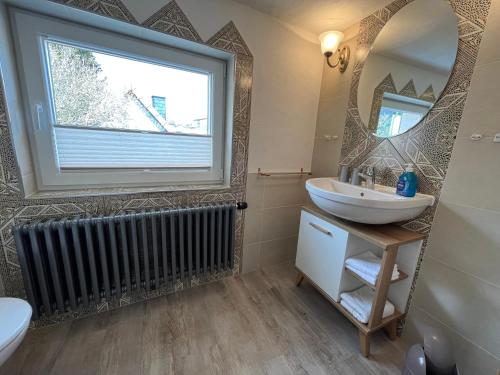 a bathroom with a sink and a large window at Ferienwohnung - Haus Molle in Benneckenstein