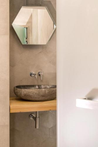 a bathroom with a stone sink and a mirror at Tsikeli Boutique Hotel Meteora - Adults Friendly in Kalabaka